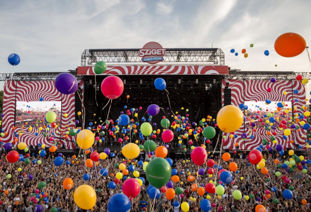 Drone photo of a large stage with colorful balloons floating to the sky
