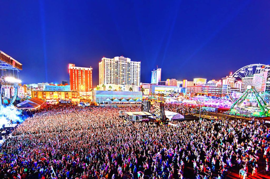 Drone photo of huge crowd at Las Vegas Life is Beautiful Musical Festival. Bright city lights and pigmented image.