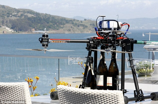 A drone holding champagne bottles on a table.